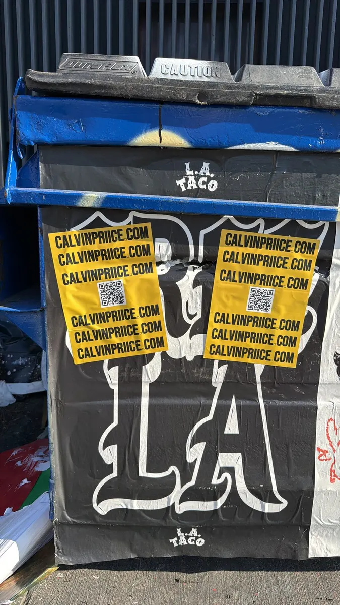 Yellow CALVINPRIICE.COM QR stickers pasted on an LA Taco street-art dumpster